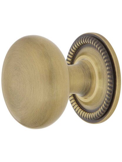 Classic Round Cabinet Knob - 1 3/8 inch Diameter with Rope Rosette in Antique Brass.
